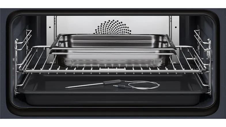 An oven interior with racks, a roasting pan, and a probe cable An oven interior with racks, a roasting pan, and a probe cable