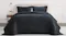 Front view of a neatly styled bed dressed in a black ruched velvet queen coverlet set Front view of a neatly styled bed dressed in a black ruched velvet queen coverlet set