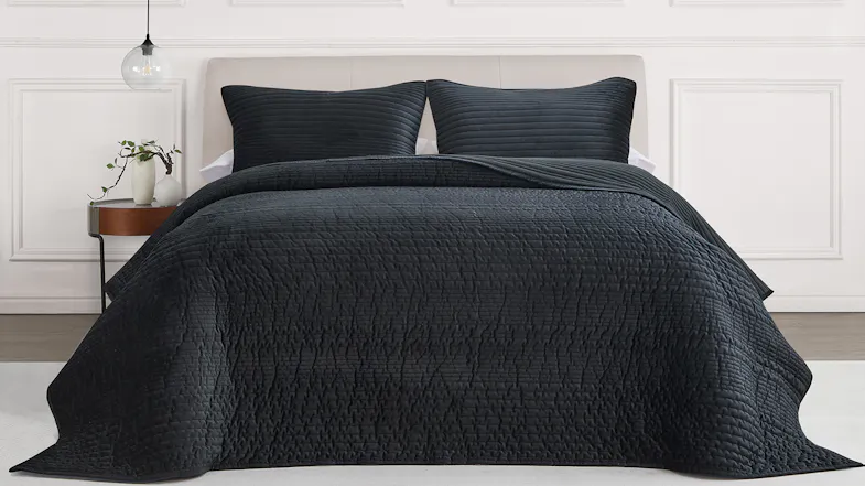 Front view of a neatly styled bed dressed in a black ruched velvet queen coverlet set Front view of a neatly styled bed dressed in a black ruched velvet queen coverlet set