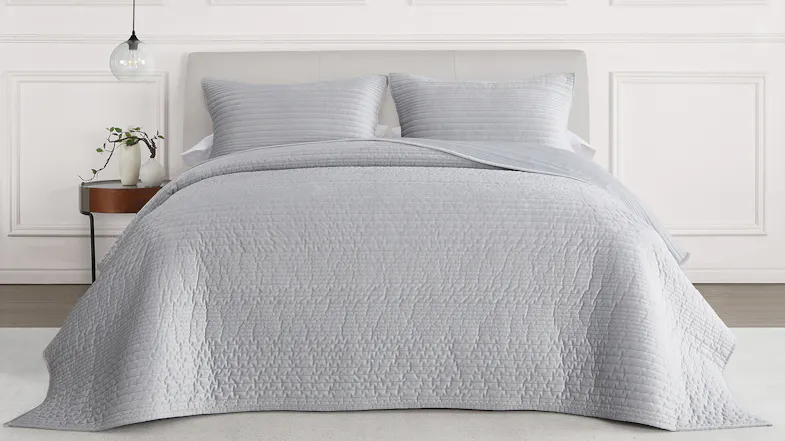 Front view of a queen bed styled with a ruched velvet coverlet in a soft silver‑grey tone Front view of a queen bed styled with a ruched velvet coverlet in a soft silver‑grey tone