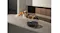 The robotic vacuum operates on a smooth floor near a wall, cleaning scattered pet food beside two raised bowls The robotic vacuum operates on a smooth floor near a wall, cleaning scattered pet food beside two raised bowls