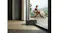 The robotic vacuum climbs a low threshold between indoor and outdoor flooring near a glass door The robotic vacuum climbs a low threshold between indoor and outdoor flooring near a glass door