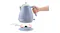 A hand lifts the De'Longhi kettle off its circular power base, demonstrating cordless use A hand lifts the De'Longhi kettle off its circular power base, demonstrating cordless use
