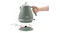 A hand lifts the De'Longhi kettle off its circular power base, demonstrating cordless use A hand lifts the De'Longhi kettle off its circular power base, demonstrating cordless use