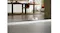 The robotic vacuum crossing a low floor threshold between rooms The robotic vacuum crossing a low floor threshold between rooms
