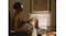 Indoor scene showing a person holding a smartphone near the Roborock docking station Indoor scene showing a person holding a smartphone near the Roborock docking station