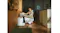 A person kneeling beside the docking station while placing or removing a rectangular water tank A person kneeling beside the docking station while placing or removing a rectangular water tank