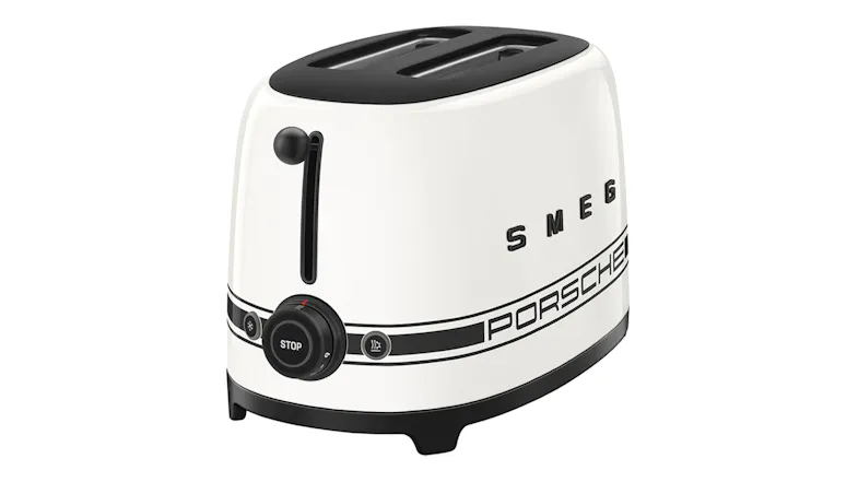 Angled view of a white Smeg Porsche Edition toaster with black racing stripes and logo Angled view of a white Smeg Porsche Edition toaster with black racing stripes and logo