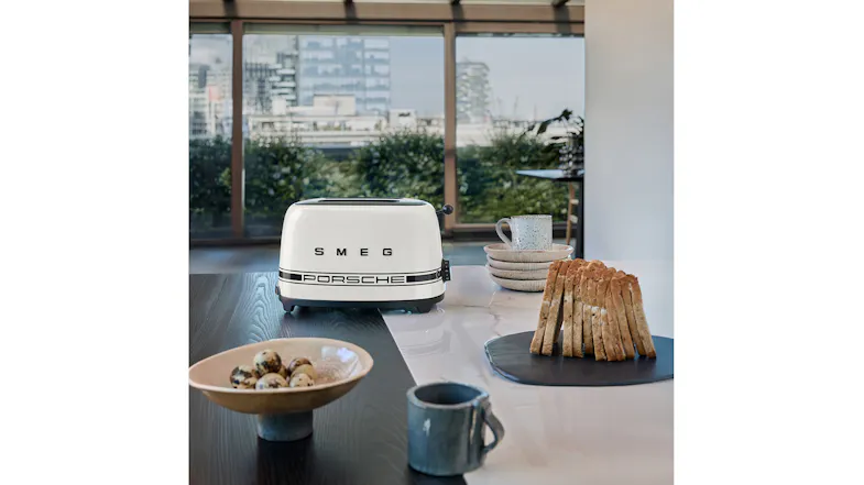 Smeg Porsche toaster on a kitchen island next to a stack of toasted bread slices Smeg Porsche toaster on a kitchen island next to a stack of toasted bread slices