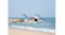 Front view of a grey drone hovering over a sandy beach Front view of a grey drone hovering over a sandy beach