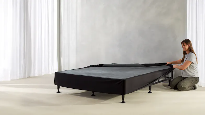 The black upholstered cover smoothed and secured around the entire bed base The black upholstered cover smoothed and secured around the entire bed base
