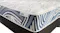 Close‑up of the Dream Medium mattress corner showing the white quilted sleep surface and blue patterned side panel Close‑up of the Dream Medium mattress corner showing the white quilted sleep surface and blue patterned side panel