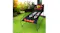 Basketball arcade game placed on grass in a garden setting, surrounded by plants and sunlight Basketball arcade game placed on grass in a garden setting, surrounded by plants and sunlight
