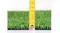 Side view of olive green artificial grass with a yellow measuring tape placed vertically against the edge Side view of olive green artificial grass with a yellow measuring tape placed vertically against the edge