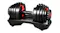 Adjustable dumbbell set with black plates and red accents resting on a moulded storage cradle Adjustable dumbbell set with black plates and red accents resting on a moulded storage cradle