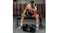 Person seated on a bench performing a dumbbell curl, with adjustable dumbbells on the floor Person seated on a bench performing a dumbbell curl, with adjustable dumbbells on the floor