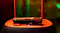 A microphone resting horizontally on the textured top of a speaker A microphone resting horizontally on the textured top of a speaker