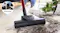 Close-up view of the ProPower floor nozzle cleaning dirt from a white rug Close-up view of the ProPower floor nozzle cleaning dirt from a white rug