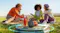 Four friends are having a picnic around the glowing speaker Four friends are having a picnic around the glowing speaker
