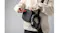 Headphones hang from the strap of a person's black crossbody bag Headphones hang from the strap of a person's black crossbody bag