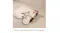 The Dyson Supersonic Travel hair dryer is lying on a light, textured surface with the power cord loosely arranged The Dyson Supersonic Travel hair dryer is lying on a light, textured surface with the power cord loosely arranged
