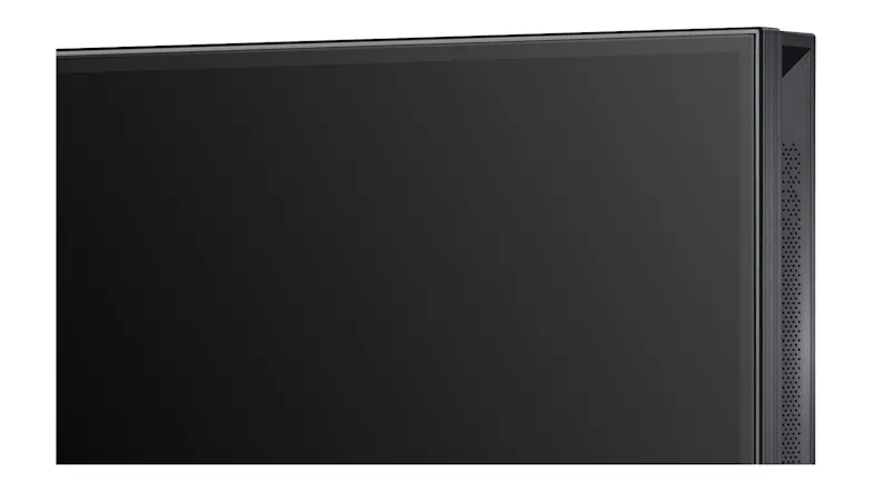 Close‑up of the TV’s front corner showing a slim black bezel, matte screen surface, and fine side speaker Close‑up of the TV’s front corner showing a slim black bezel, matte screen surface, and fine side speaker