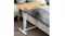 Side table next to a bed, showing the power outlets, cable access, and adjustable height for bedside use Side table next to a bed, showing the power outlets, cable access, and adjustable height for bedside use