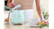 A person opening the pastel green lid of the SMEG kettle in a modern kitchen A person opening the pastel green lid of the SMEG kettle in a modern kitchen