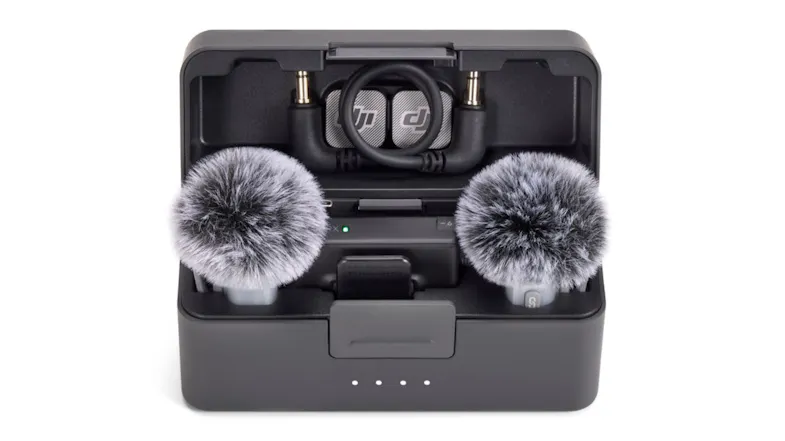 An open DJI Mic Mini 2 charging case with two furry windshields and the receiver inside An open DJI Mic Mini 2 charging case with two furry windshields and the receiver inside