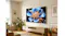 Wide living room scene with the TCL TV mounted above a console, surrounded by plants and framed artwork Wide living room scene with the TCL TV mounted above a console, surrounded by plants and framed artwork