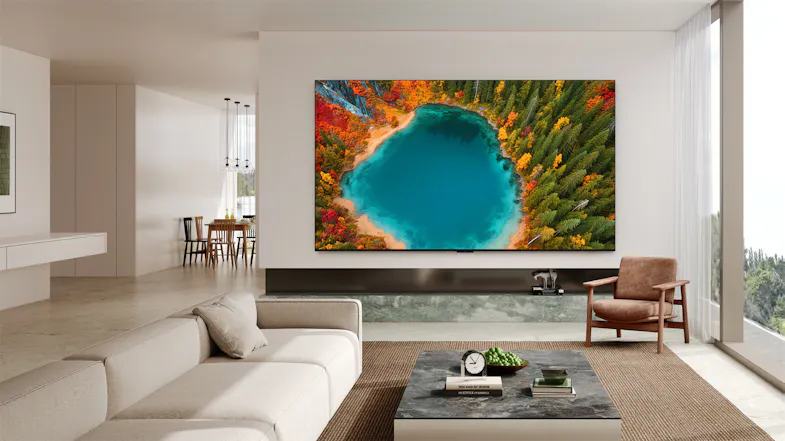 Daytime living room scene with the TV wall‑mounted above a low console, showing a vivid aerial lake image Daytime living room scene with the TV wall‑mounted above a low console, showing a vivid aerial lake image