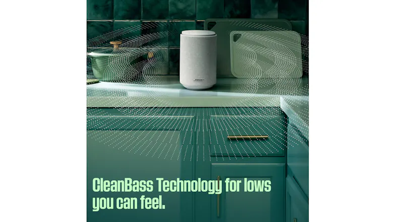 Lifestyle kitchen scene showing the white Bose speaker on a countertop with stylised sound wave graphics Lifestyle kitchen scene showing the white Bose speaker on a countertop with stylised sound wave graphics