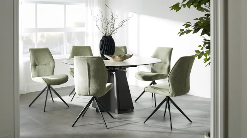 Oval light-top dining table with a black geometric base, surrounded by six olive green upholstered chairs Oval light-top dining table with a black geometric base, surrounded by six olive green upholstered chairs