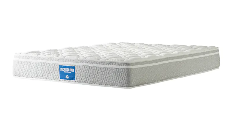 A left-angled view of the Incredi‑Bed medium mattress showing quilted comfort top, textured side panels, and logo badge A left-angled view of the Incredi‑Bed medium mattress showing quilted comfort top, textured side panels, and logo badge