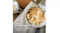 A bowl of yoghurt topped with banana slices and granola on a table A bowl of yoghurt topped with banana slices and granola on a table