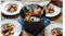 A large dark grey Ninja cooking pot filled with steaming beef stew, potatoes, carrots, and onions sits on a table A large dark grey Ninja cooking pot filled with steaming beef stew, potatoes, carrots, and onions sits on a table