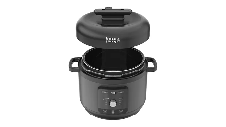 The pressure cooker shown with the lid lifted off, revealing the removable inner cooking pot inside the base unit The pressure cooker shown with the lid lifted off, revealing the removable inner cooking pot inside the base unit