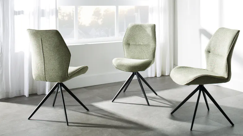 Three olive fabric dining chairs displayed together, featuring curved backs, textured upholstery, and black legs Three olive fabric dining chairs displayed together, featuring curved backs, textured upholstery, and black legs