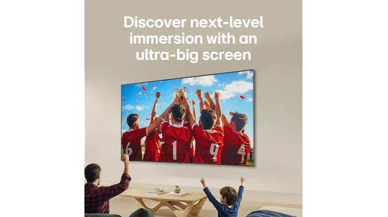 Large TV showing a soccer celebration, with people raising their arms in a living room Large TV showing a soccer celebration, with people raising their arms in a living room