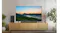 Living room TV displaying a green mountain landscape at sunrise with mist, surrounded by plants and a sound system Living room TV displaying a green mountain landscape at sunrise with mist, surrounded by plants and a sound system