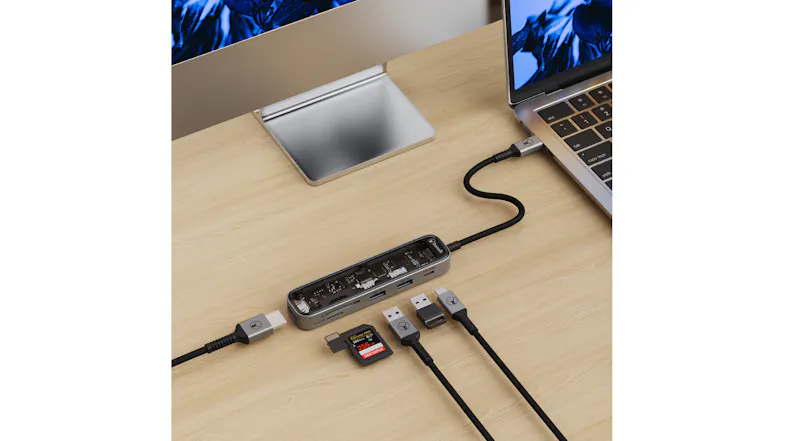 Top-down view of the Bon.Elk Vision USB-C hub beside a laptop, with connected cables and USB drives on the desk Top-down view of the Bon.Elk Vision USB-C hub beside a laptop, with connected cables and USB drives on the desk
