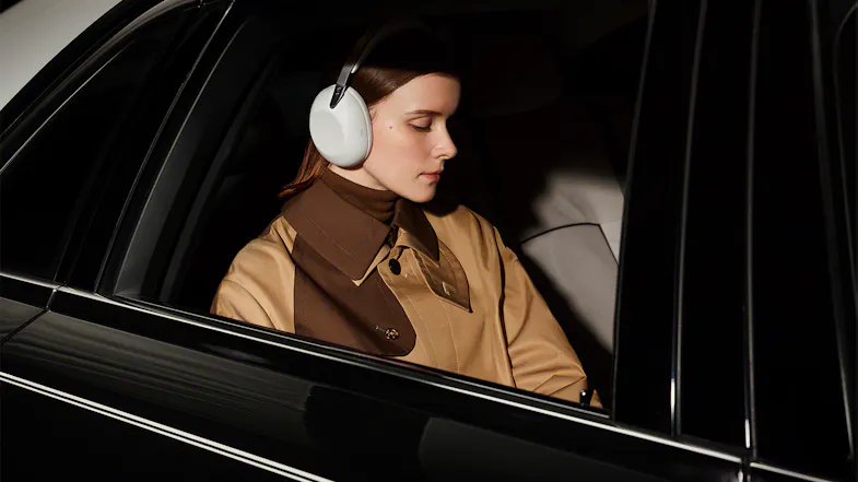 Woman inside a car listening to music using the Wireless Over-Ear Headphones Woman inside a car listening to music using the Wireless Over-Ear Headphones