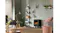 Cozy living room with a black Dimplex electric fireplace, armchairs, plants, shelves, and soft daylight through blinds Cozy living room with a black Dimplex electric fireplace, armchairs, plants, shelves, and soft daylight through blinds