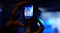 Close-up of a camera screen capturing a stage scene with blue lighting, with the performance visible on the display Close-up of a camera screen capturing a stage scene with blue lighting, with the performance visible on the display