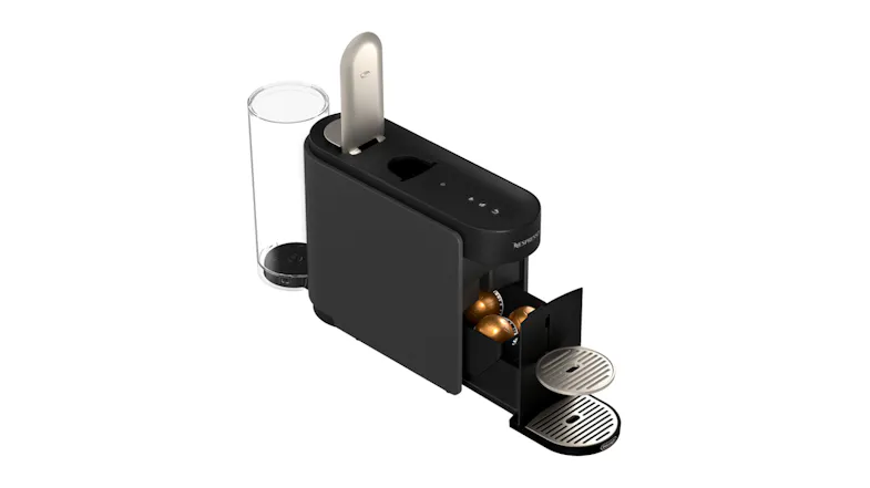 A black Nespresso machine with the lid open and the capsule compartment visible, showing coffee pods inside A black Nespresso machine with the lid open and the capsule compartment visible, showing coffee pods inside