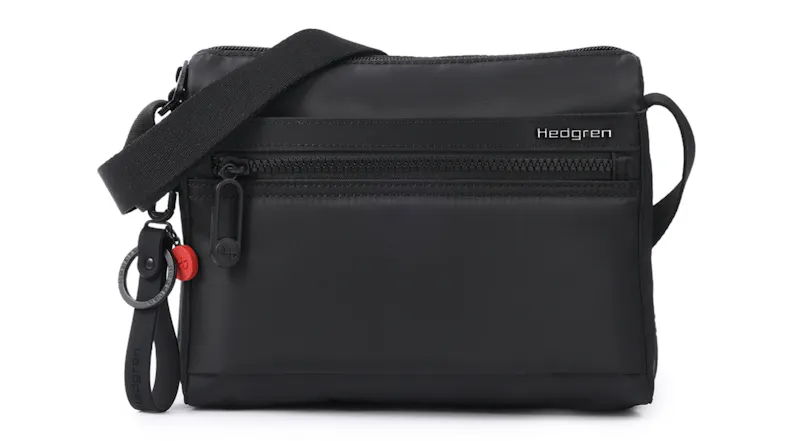 Front view of the black Hedgren “Eye” RFID-protected crossbody bag with a front zip pocket, logo, and detachable loop keychain Front view of the black Hedgren “Eye” RFID-protected crossbody bag with a front zip pocket, logo, and detachable loop keychain