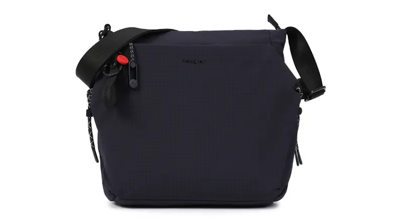 Front view of a dark blue Hedgren "Makoto" Crossbody Bag with adjustable strap and small clip accessories Front view of a dark blue Hedgren "Makoto" Crossbody Bag with adjustable strap and small clip accessories
