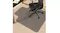 Black office chair on a clear anti-slip floor mat under the desk, protecting carpet with textured grip surface and cutout shape Black office chair on a clear anti-slip floor mat under the desk, protecting carpet with textured grip surface and cutout shape