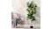Lambu artificial fiddle leaf fig tree in a black pot beside a pink armchair with a grey throw against a marble wall Lambu artificial fiddle leaf fig tree in a black pot beside a pink armchair with a grey throw against a marble wall