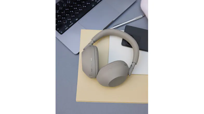 The Sony headphones were placed on top of the table, together with the laptop and phone The Sony headphones were placed on top of the table, together with the laptop and phone